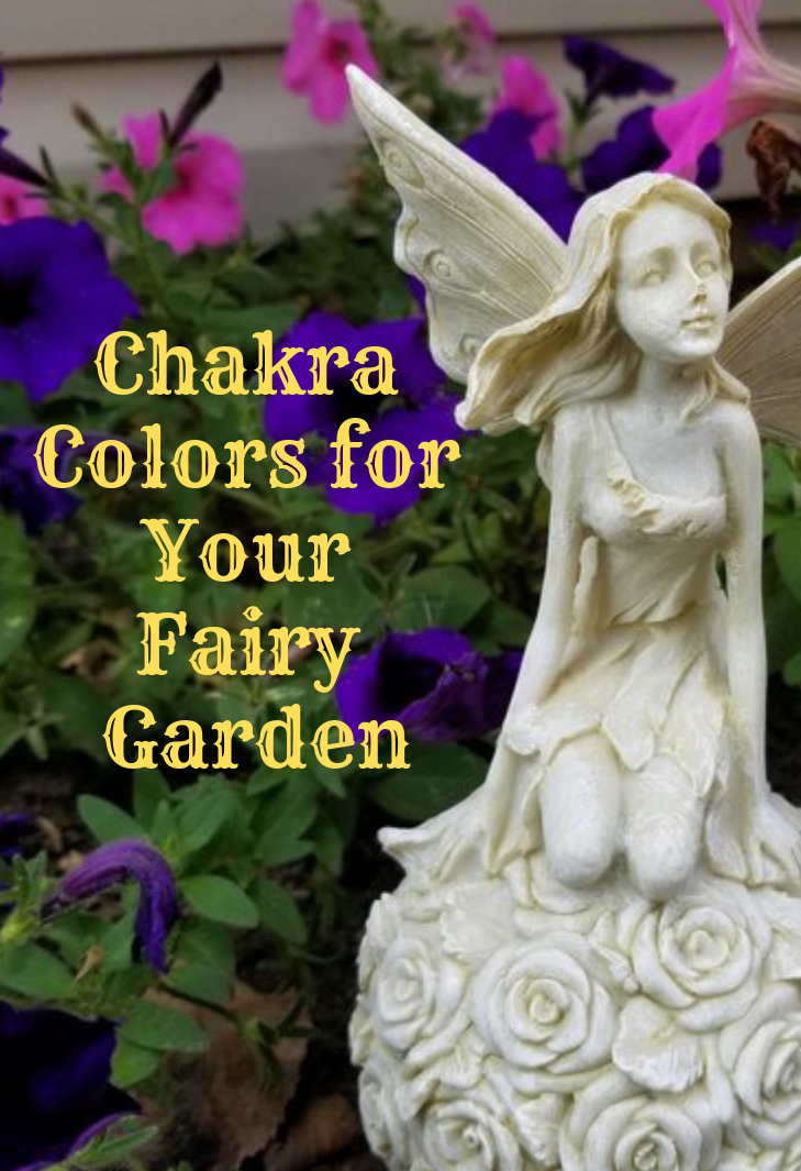 A white fairy figurine in a garden with the blog post words chakra colors for your fairy garden