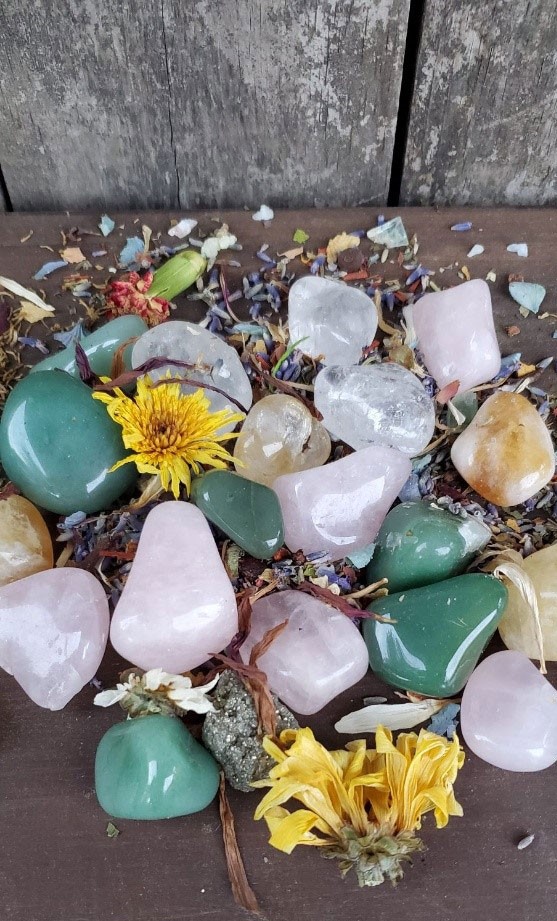 Polished crystals of citrine, pink quartz clear quartz and others on a wood table