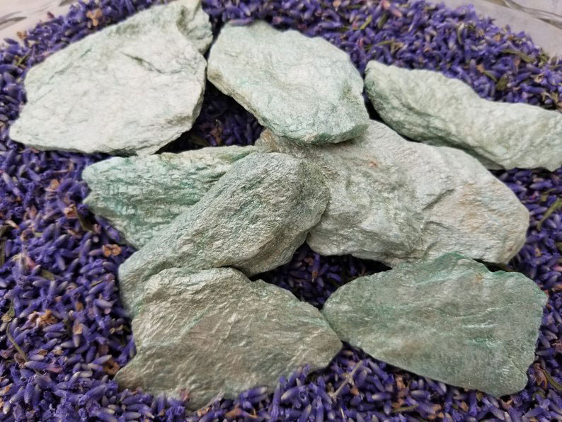 Several pieces of glittery Fuchsite stones on dried purple lavender