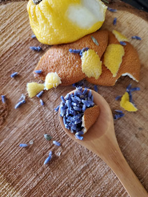 purple lavender buds on a wooden spoon with dried lemon