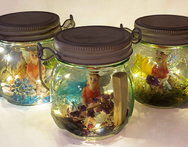 3 completed fairy lights jars with sitting fairy, dried flowers, palo santo stick, crystals, feather, mushroom, water beads, seashells