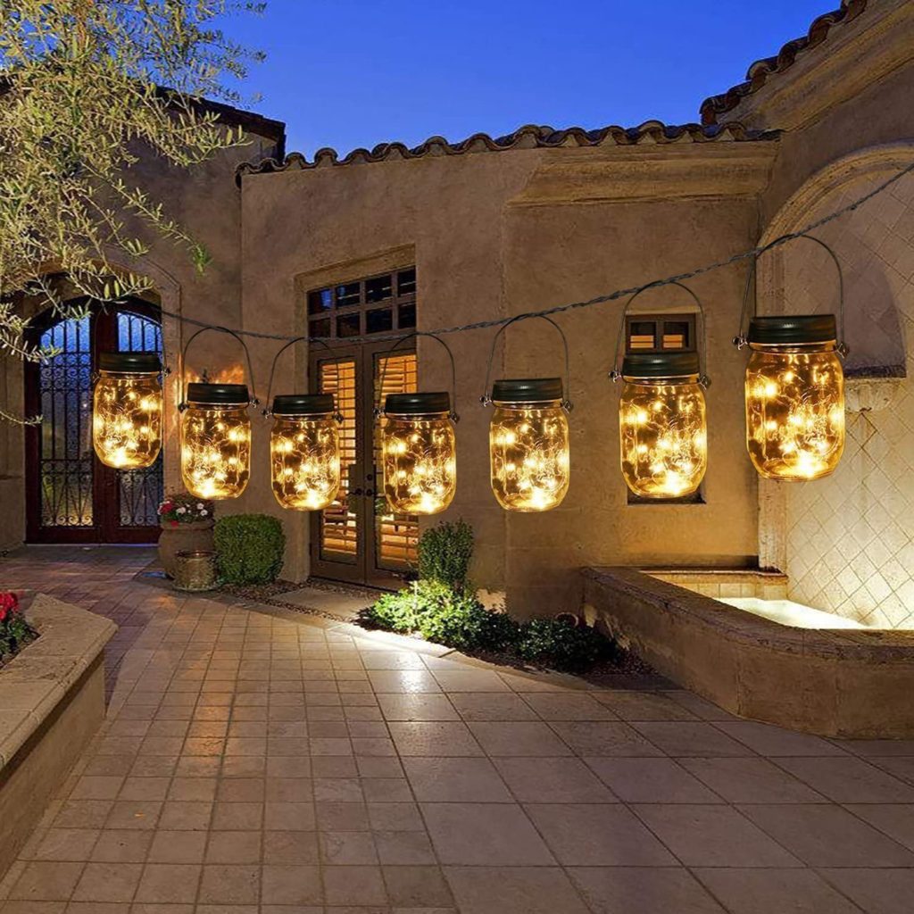 Lighted jars hanging like tiki lights near a house